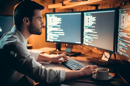 Computer Programmer Coding at His Desk