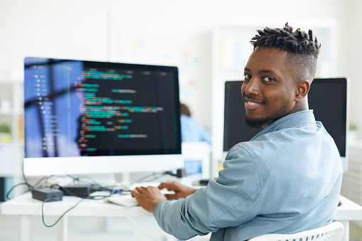 Man on computer happily using his programming and development skills.
