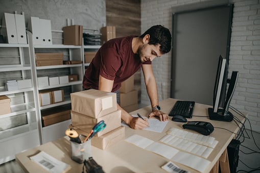 Man studying logistics in a warehouse office